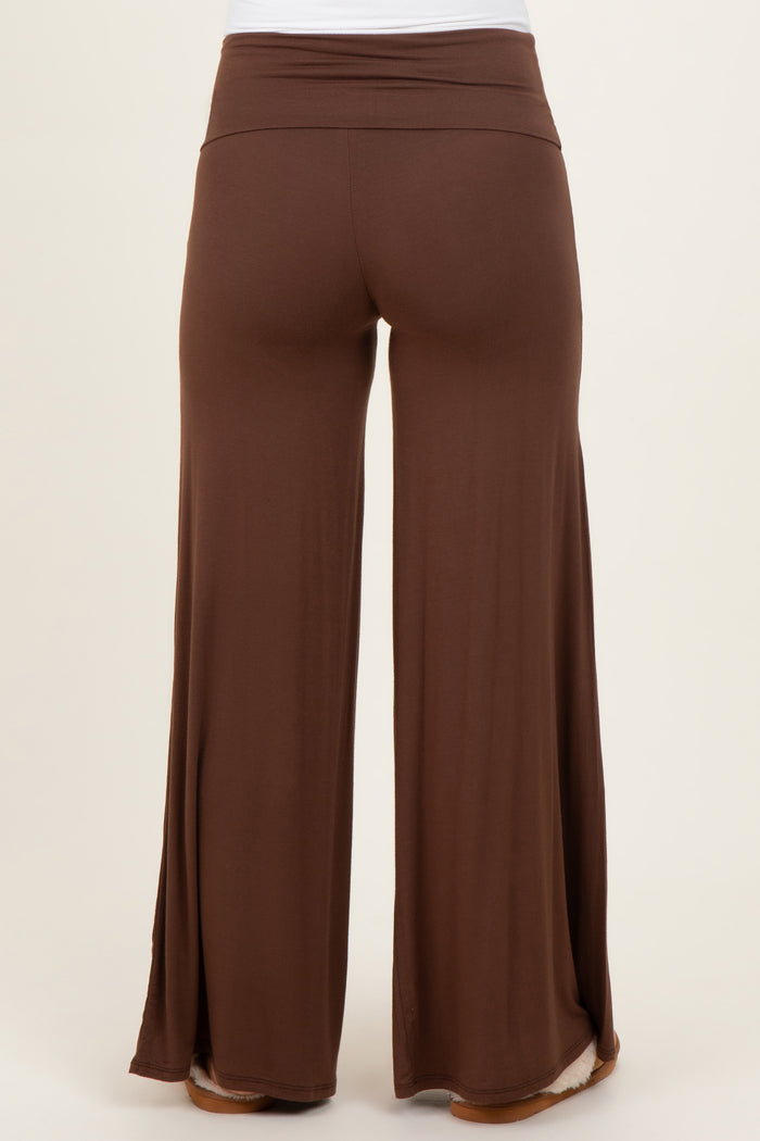 woman wearing brown maternity wide leg pants with a comfortable high waistband and side slits at the hem