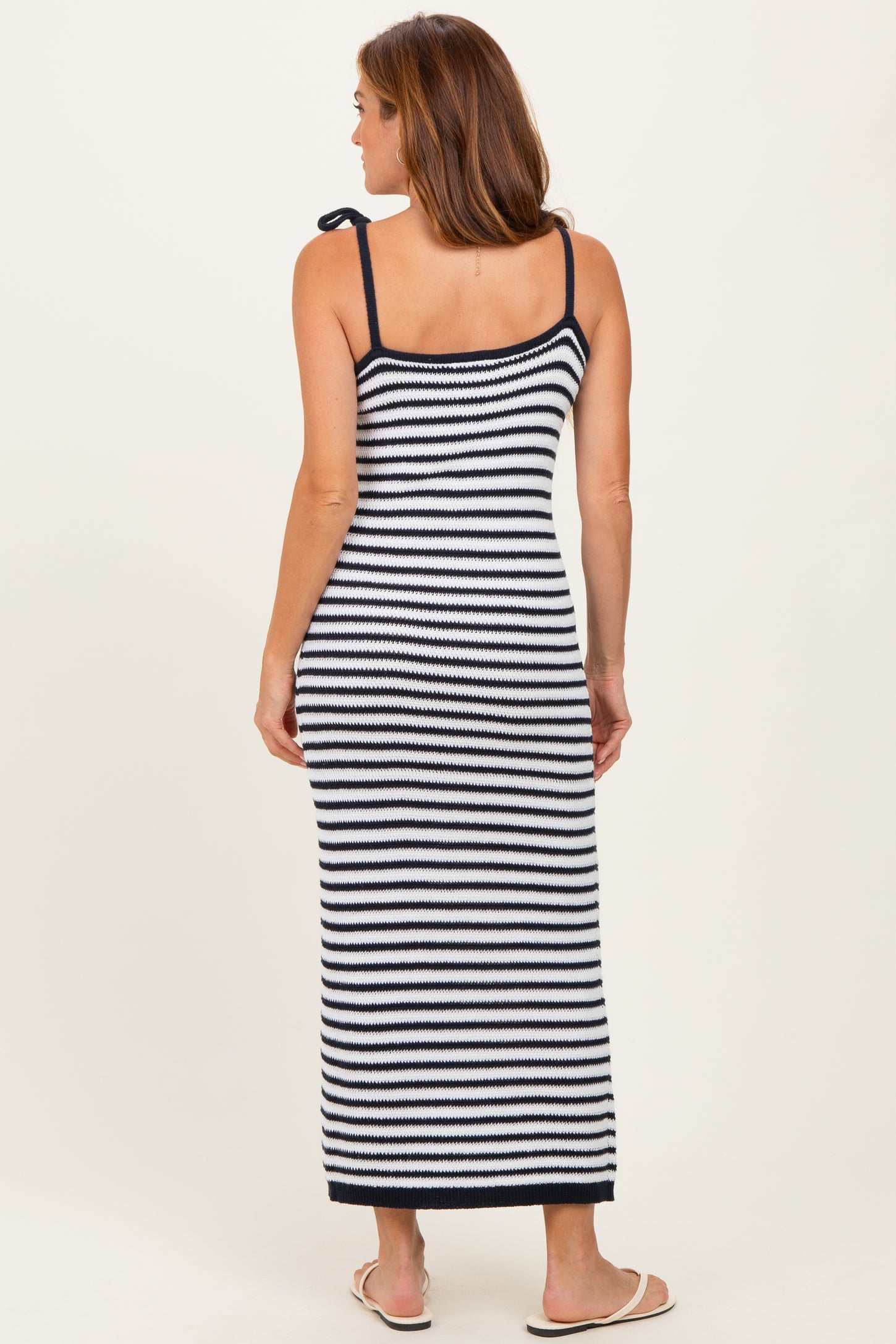 woman wearing a navy and white striped long maxi dress with adjustable straps