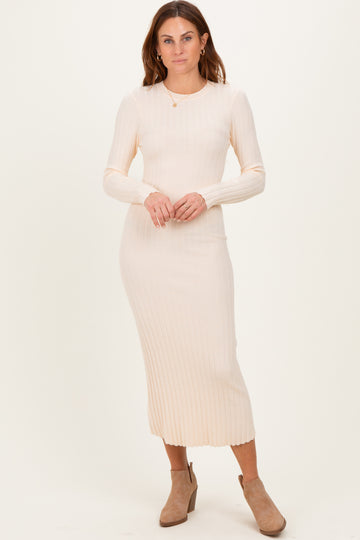woman wearing a light beige ribbed long sleeve midi dress and ankle boots
