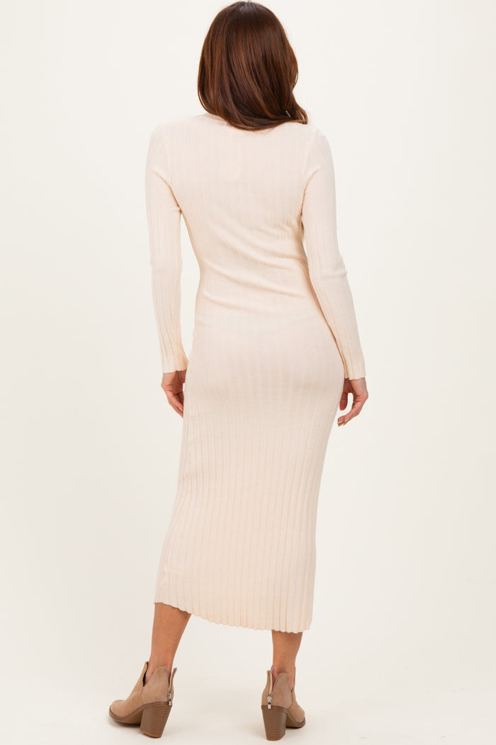 woman wearing a fitted light beige ribbed midi dress with long sleeves and a side slit, seen from the back