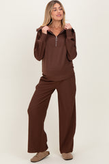 woman wearing a brown ribbed maternity loungewear set with a half-zip hoodie and wide-leg pants