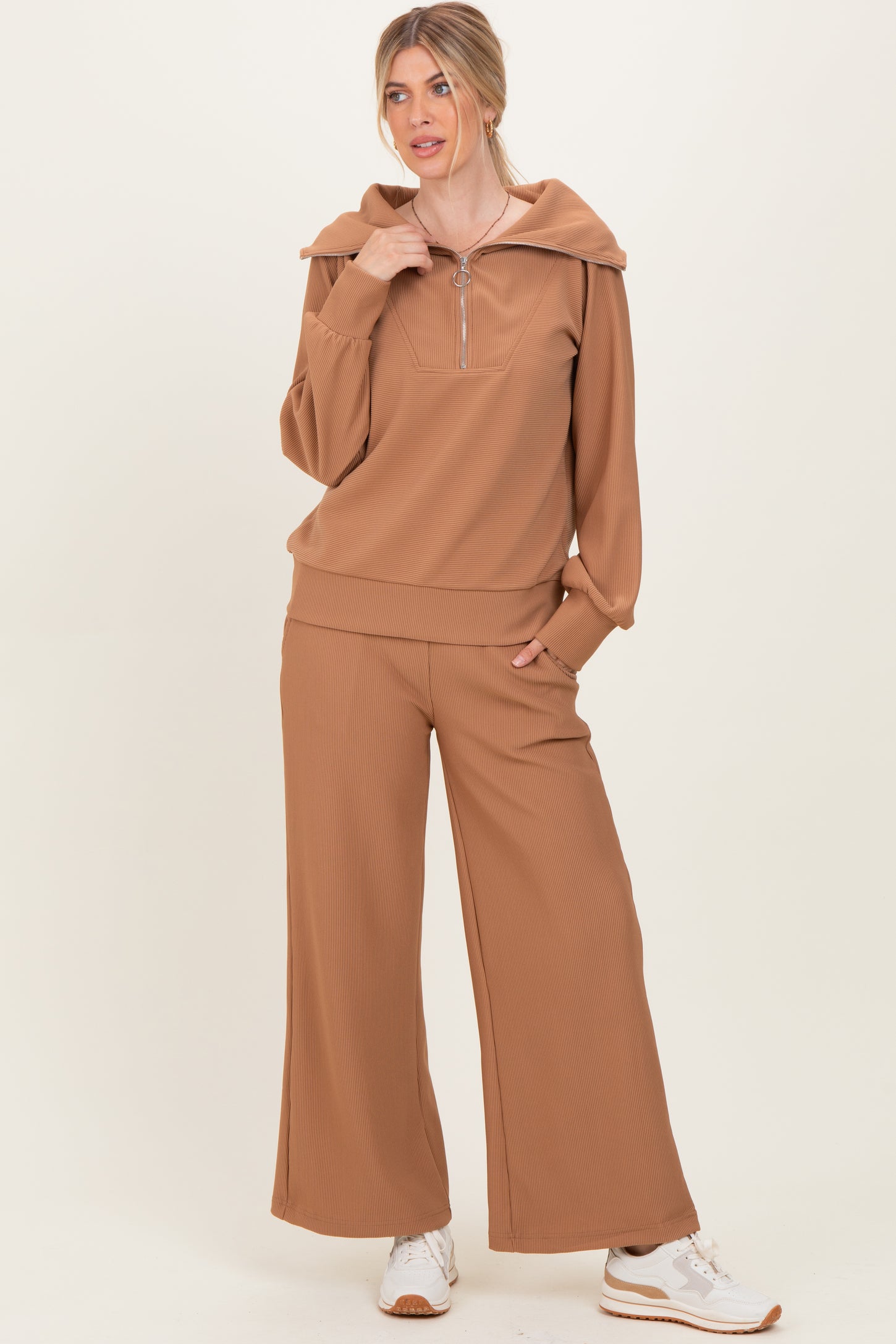 woman wearing a brown ribbed zip-up hoodie and matching wide-leg pants with a collar detail and white sneakers