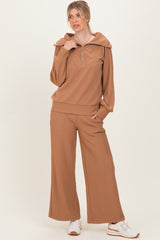 woman wearing a brown ribbed zip-up hoodie and matching wide-leg pants with a collar detail and white sneakers