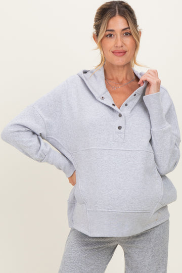 woman wearing a gray maternity hoodie with buttons and a relaxed fit, showcasing her baby bump