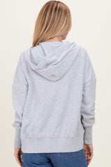 woman wearing a gray oversized hoodie with a hood and long sleeves, viewed from the back
