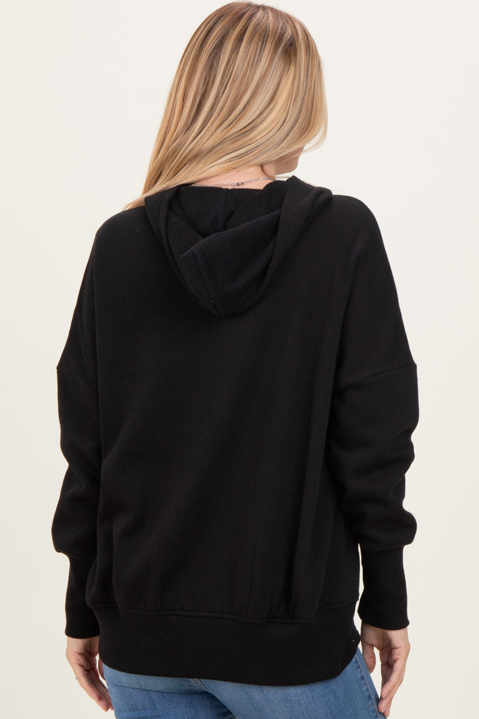 woman wearing a black oversized hoodie viewed from the back, styled with casual blue jeans
