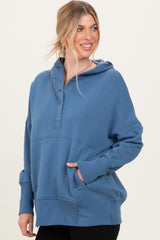 woman wearing a blue hooded sweatshirt with a button-up neckline and front pocket