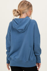 woman wearing a blue oversized hoodie with a hood and a loose fit, shown from the back