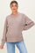 woman wearing a beige ribbed maternity sweater with a relaxed fit and side slits, posing with one hand on her hip