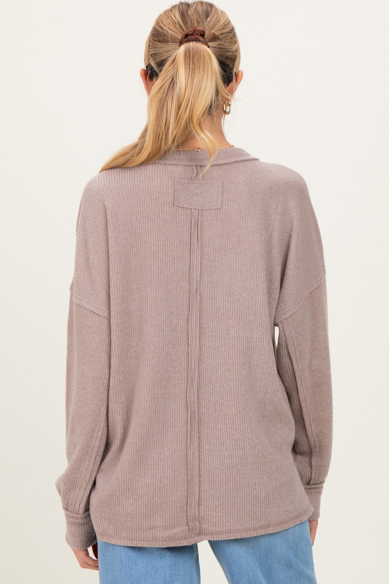 woman wearing a mauve oversized ribbed back seam maternity sweater, showing a relaxed fit and long sleeves
