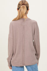 woman wearing a mauve oversized ribbed back seam maternity sweater, showing a relaxed fit and long sleeves