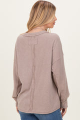 woman wearing a taupe ribbed long sleeve top with a back seam detail and relaxed fit