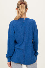 woman wearing a blue oversized knitted maternity sweater, with a loose fit and long sleeves, showing the back view