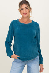 woman wearing a teal long sleeve maternity sweater with a relaxed fit and a round neckline