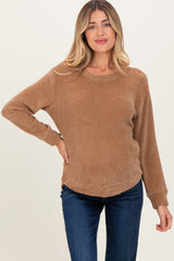 woman wearing a brown long sleeve maternity top with a relaxed fit and rounded hem, showcasing her baby bump