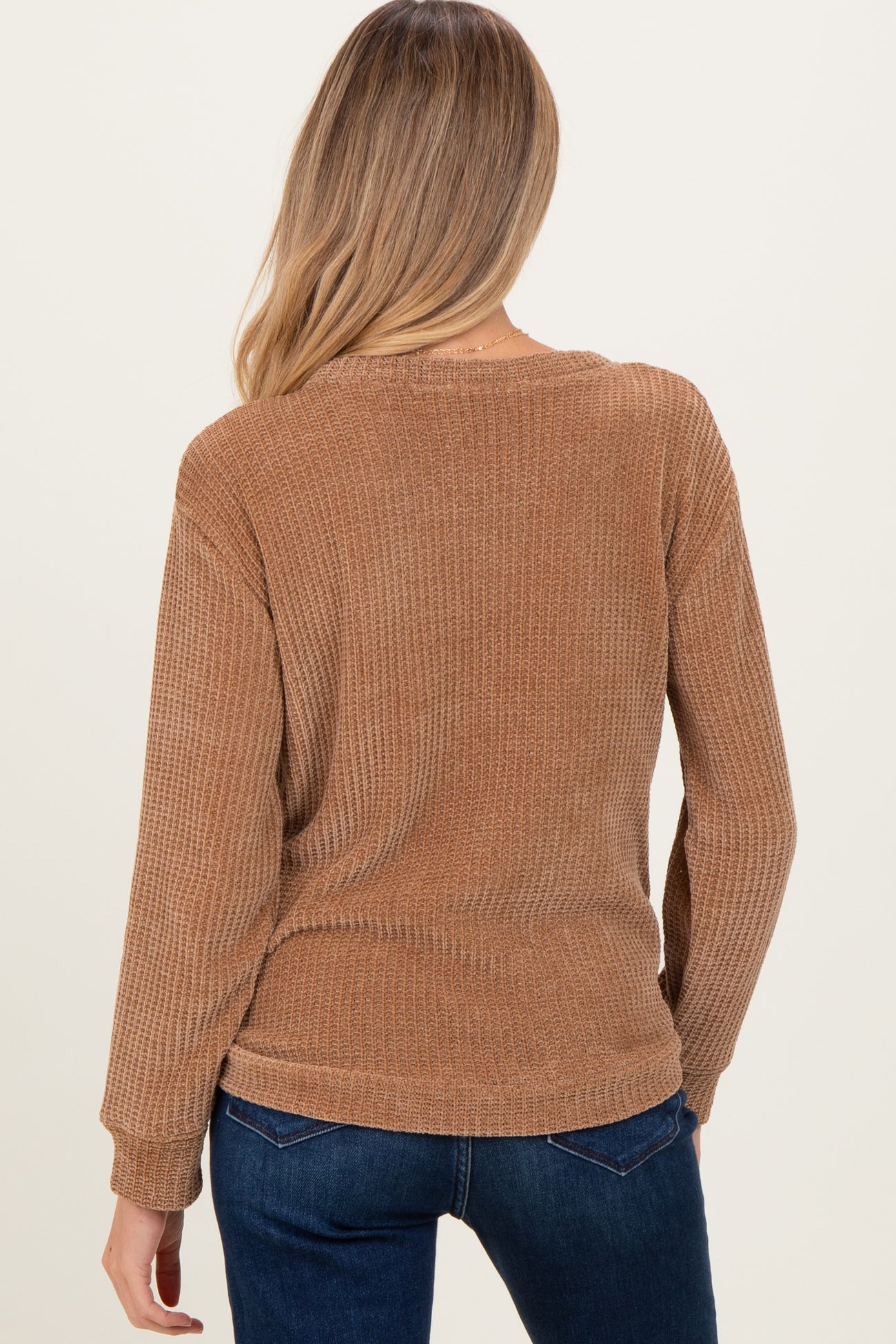 woman wearing a brown long sleeve maternity top with a textured finish, viewed from the back
