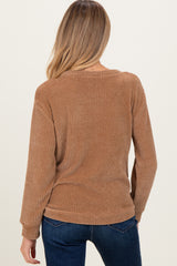 woman wearing a brown long sleeve maternity top with a textured finish, viewed from the back