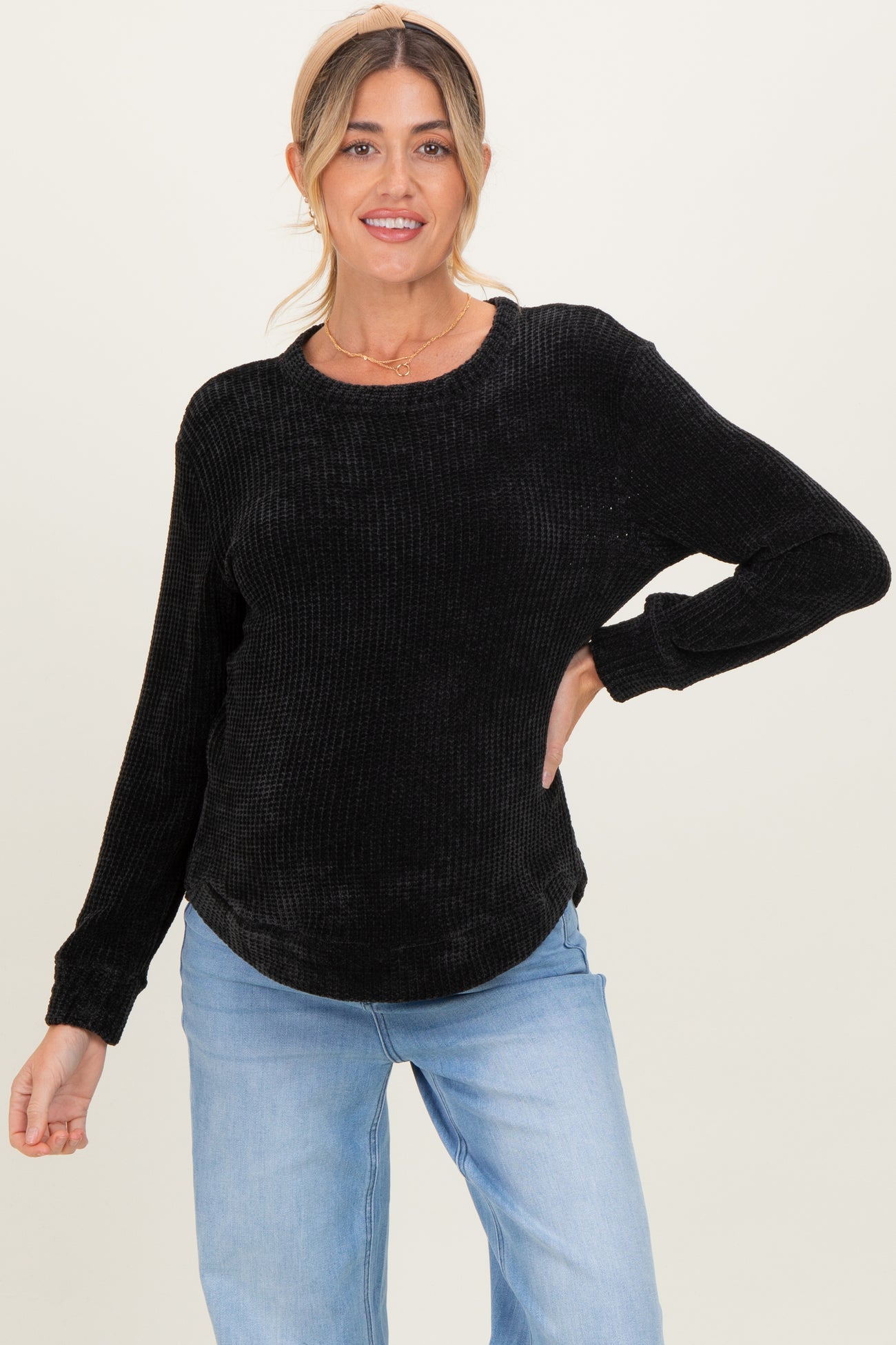 woman wearing a black ribbed maternity sweater with long sleeves and a relaxed fit
