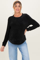 woman wearing a black ribbed maternity sweater with long sleeves and a relaxed fit