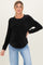 woman wearing a black ribbed maternity sweater with long sleeves and a relaxed fit