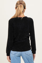 woman wearing a black ribbed maternity top with long sleeves, seen from the back