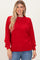 woman wearing a cozy red ribbed sweater with long sleeves and relaxed fit paired with blue jeans
