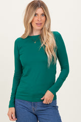 woman wearing a green long sleeve top and blue jeans