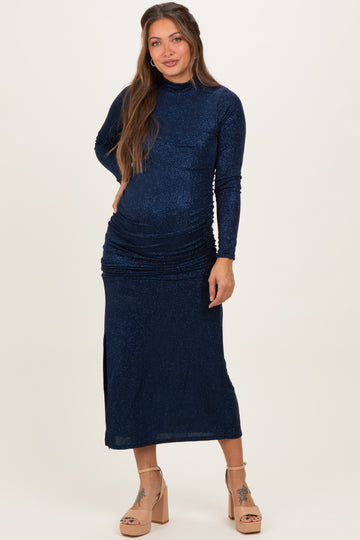 woman wearing a navy blue long sleeve maternity dress with ruching and a side slit, showing her baby bump