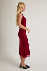 woman wearing a burgundy sleeveless midi dress with a fitted silhouette and a flowy hem