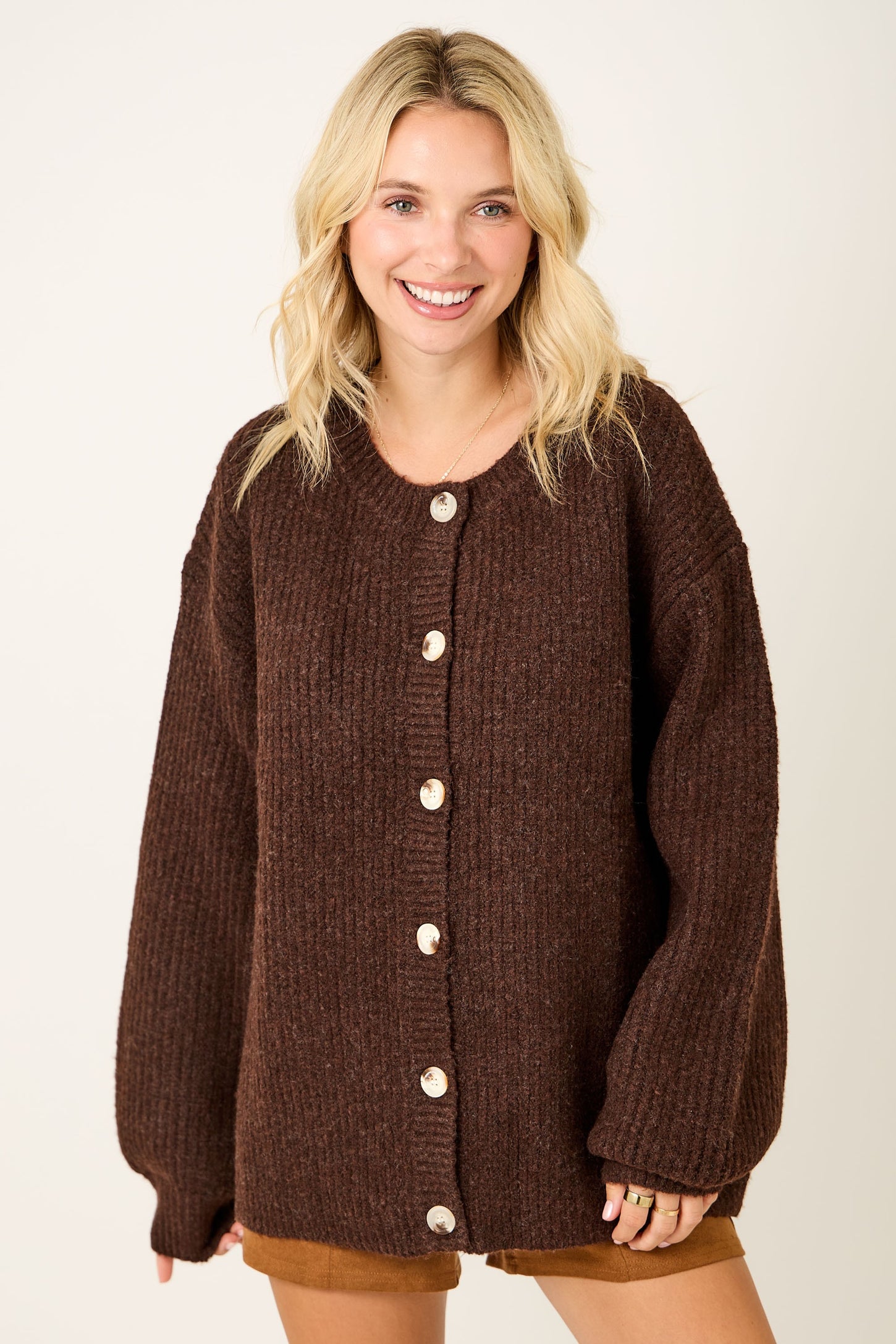 woman wearing a brown oversized button-up sweater with ribbed texture and drop shoulders