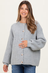 woman wearing a light gray button-up maternity sweater with ribbed texture and a visible baby bump