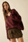 woman wearing a burgundy oversized sweater and a brown leopard print mini skirt