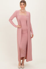 woman wearing a long pink ribbed cardigan over a matching fitted dress with a square neckline and long sleeves