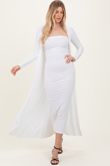 woman wearing a white ribbed midi dress with a long cardigan and strappy black heels
