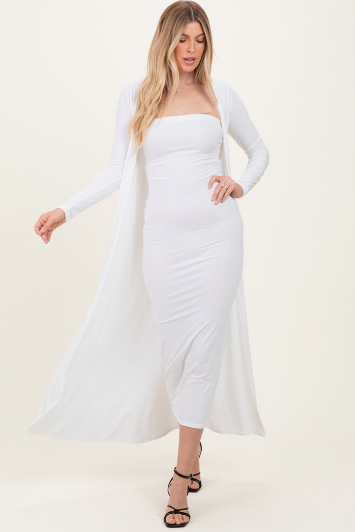 woman wearing a white ribbed midi dress with a long cardigan and strappy black heels