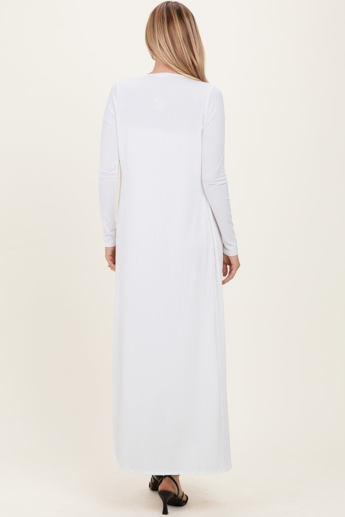 woman wearing a long white ribbed maxi dress with long sleeves, shown from the back