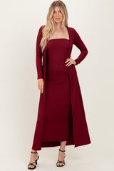 woman wearing a burgundy ribbed midi dress with a long open cardigan and strappy black heels