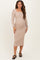 woman wearing a beige long sleeve maternity dress with a square neckline and a fitted silhouette, showing her baby bump