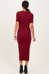 woman wearing a burgundy midi bodycon dress with short sleeves and a side slit, view from the back