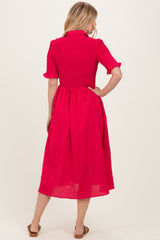 woman wearing a pink smocked midi dress with short sleeves and a button-down collar, showing the back view