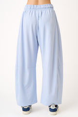 woman wearing light blue wide-leg pants with an elastic waistband, viewed from the back