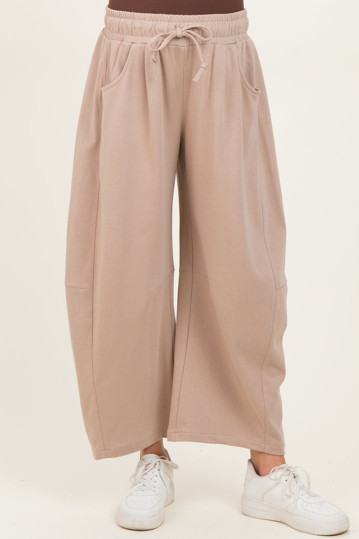woman wearing beige wide-leg maternity pants with pockets and an elastic waistband