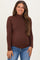 woman wearing a brown long sleeve maternity top with a mock neck and smiling, showcasing her baby bump
