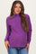 woman wearing a purple maternity sweater with a high neck and relaxed fit, showing her baby bump