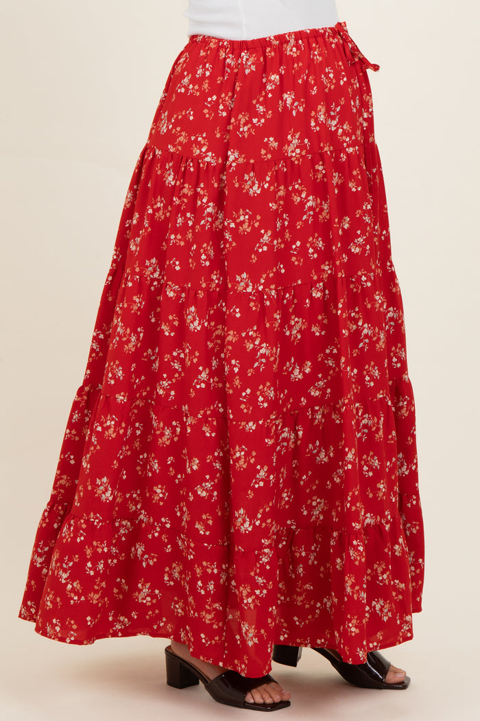 woman wearing a red floral maternity maxi skirt with a tiered design and side tie detail