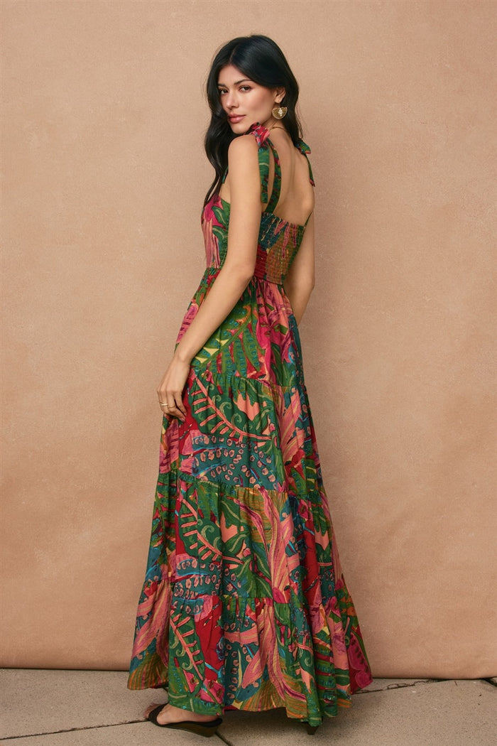 woman wearing a colorful floral print maxi dress with a back cutout and tie straps