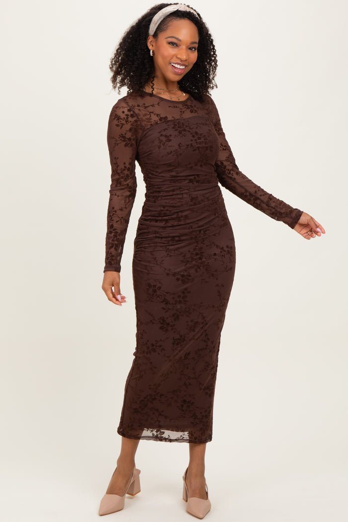 woman wearing a brown long sleeve ruched midi dress with floral lace details and styled with a headband