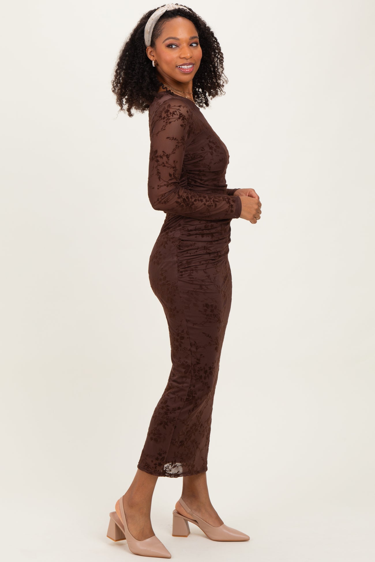 woman wearing a brown floral lace long sleeve midi dress and beige block-heeled shoes