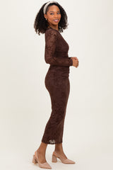 woman wearing a brown floral lace long sleeve midi dress and beige block-heeled shoes