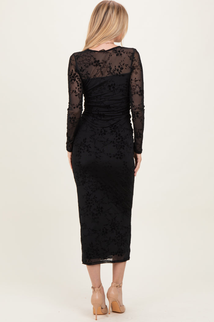 woman wearing a black long sleeve fitted dress with floral lace details, shown from the back